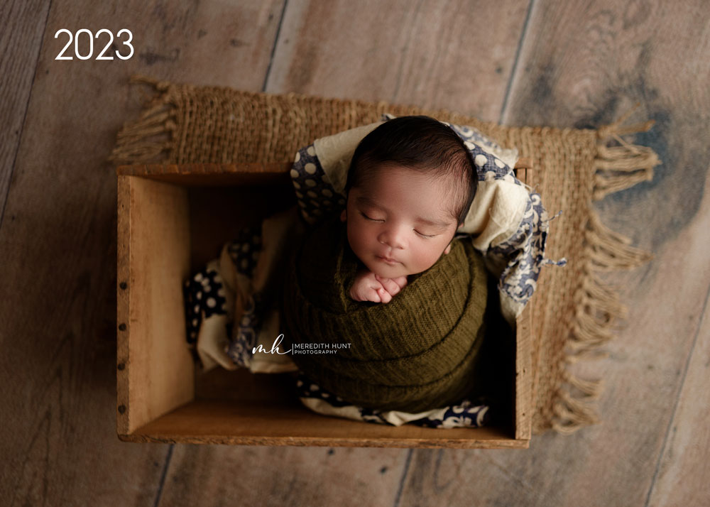 newborn boy swaddled in rustic crate
